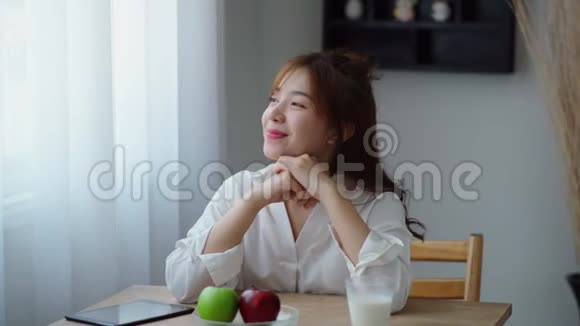 美丽的女人开心地想着吃着绿苹果视频的预览图