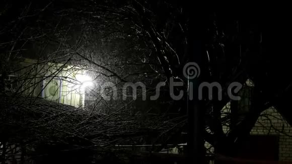 旧房子后院下雪夜晚灯火通明神秘的冬季乡村景观中期计划视频的预览图