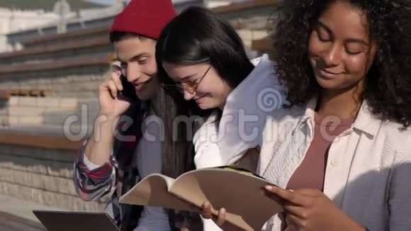 青少年在户外做作业和笑男孩在打电话视频的预览图