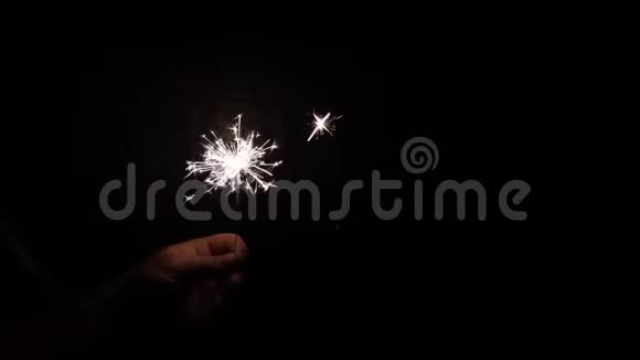 火花在黑暗的背景上燃烧手中有火花固定的概念圣诞节和新年庆祝活动视频的预览图