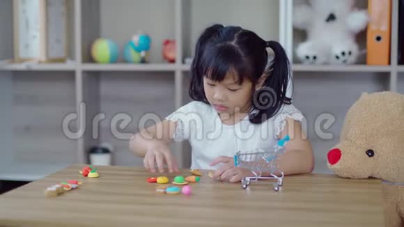 可爱的女孩在桌子上玩食物模型视频的预览图