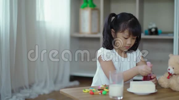 小女孩把草莓酱铺在面包片上视频的预览图