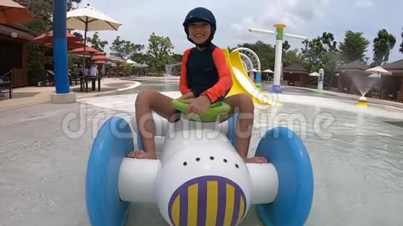 小女孩骑在水车上在水上游乐园泼水视频的预览图