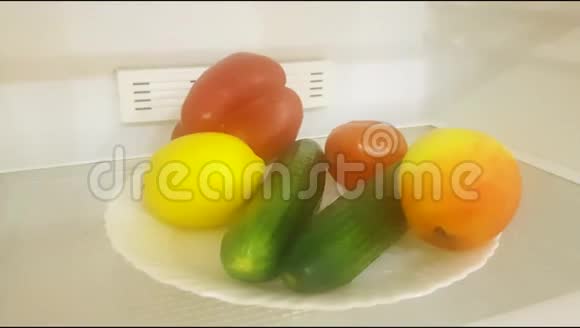 打开空冰箱在一个白色的盘子里放着蔬菜和水果吃素午餐概念合理视频的预览图