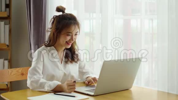 年轻女子使用信用卡进行网上购物视频的预览图