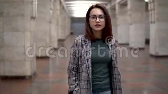 一个年轻的女人在地铁里散步一个穿外套戴眼镜的女孩视频的预览图