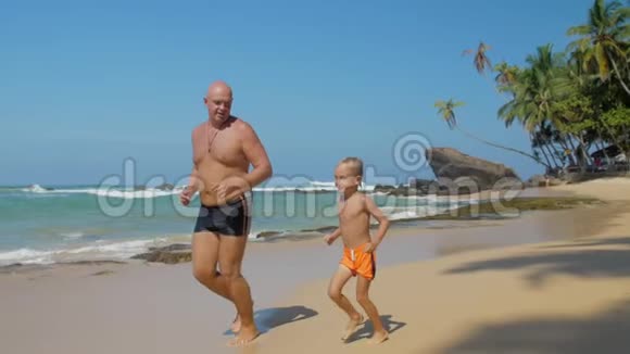 爸爸和小孩沿着异国海岸和天空奔跑视频的预览图