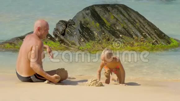 爸爸在海边和可爱的男孩一起玩沙子视频的预览图