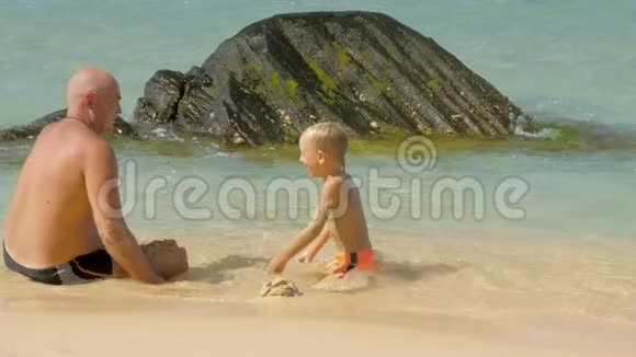 小男孩和快乐的父亲在海边度过时光视频的预览图