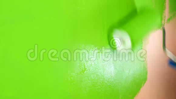 人手用油漆滚筒将粉红色的墙涂成鲜绿色中期计划视频的预览图