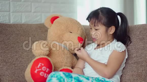 小女孩伤心地和大泰迪熊说话视频的预览图