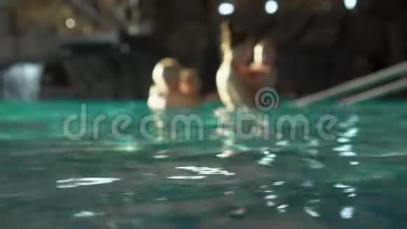 女孩在健康中心洗澡在度假慢动作美丽的女人在豪华的游泳池里放松水面视频的预览图