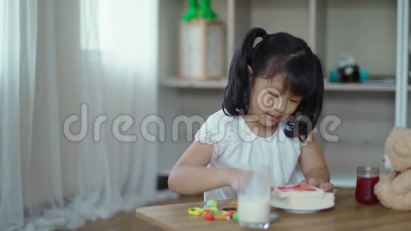 小女孩把草莓酱铺在面包片上视频的预览图