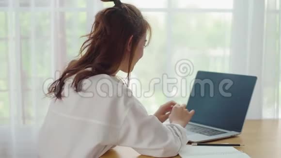 快乐的少女在家里用笔记本电脑和朋友聊天视频的预览图