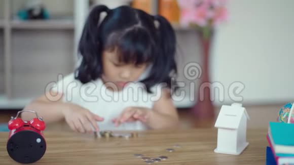 3小女孩正在收拾桌子上的硬币视频的预览图