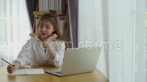 在家拿着笔记本电脑工作的漂亮女人视频的预览图