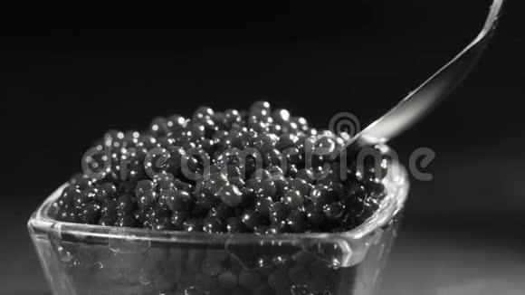 一个人用勺子从透明的碗里舀起一个美味的黑色鱼子酱美味的海鲜美食特写视频的预览图