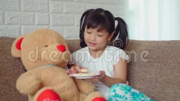 可爱的女孩分享甜点给大泰迪熊视频的预览图