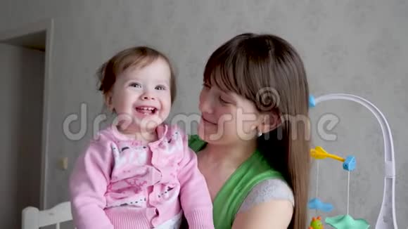 宝贝在妈妈怀里笑着玩第一颗乳牙动作缓慢视频的预览图