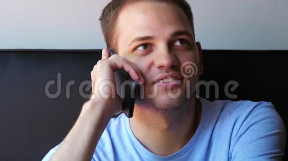 年轻健康的男人在家里用智能手机微笑和交谈视频的预览图