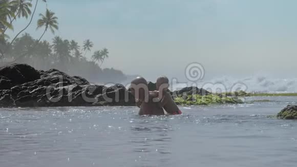积极的男人和小儿子在平静的海水中玩视频的预览图