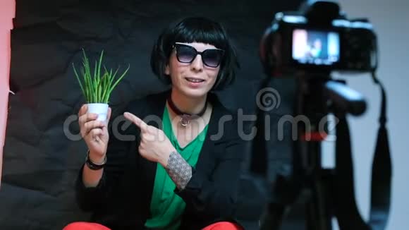 一个严格的女人和镜头谈论植物做一个视频博客视频的预览图