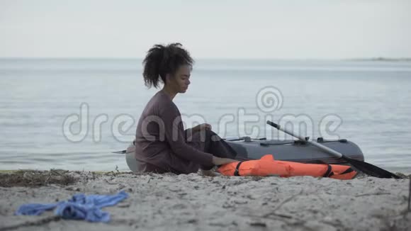 被冻死的少女坐在海边的小船旁遇难的难民幸存者视频的预览图
