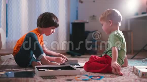 孩子们坐在地板上玩棋盘游戏视频的预览图