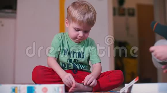 孩子坐在地板上玩个人物品视频的预览图
