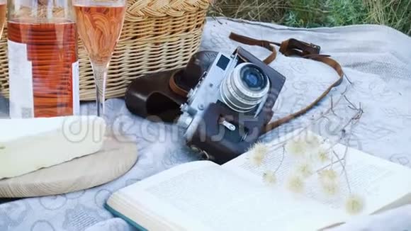 野地草地上的野餐篮和食物和一瓶酒视频的预览图