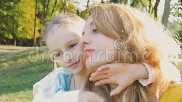 幸福的家庭在一起年轻漂亮的妈妈愉快地闭上眼睛拥抱着她可爱的小女儿阳光明媚视频的预览图