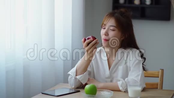 美丽的女人开心地想着吃着绿苹果视频的预览图
