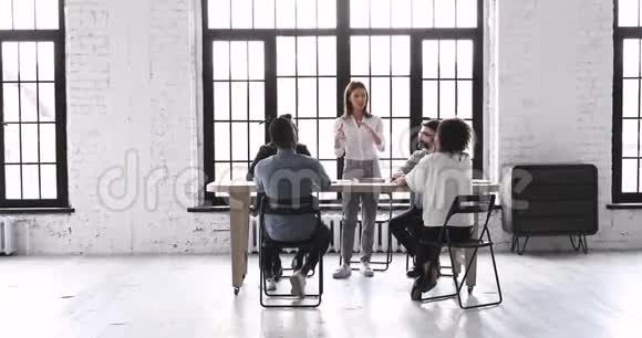在现代办公场所的小组简报会上发言的女领导视频的预览图
