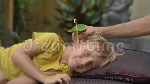 一个小男孩在热带花园的温泉里戴耳烛视频的预览图