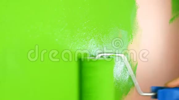 人手用油漆滚筒将粉红色的墙涂成鲜绿色特写镜头视频的预览图