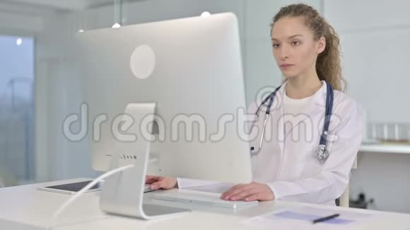 雄心勃勃的年轻女医生在办公桌上工作的画像视频的预览图