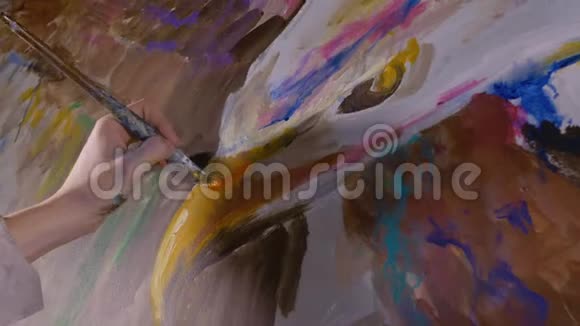 艺术家设计师在墙上画一只鹰工匠装饰师用丙烯酸油彩画一幅画近距离黑暗视频的预览图