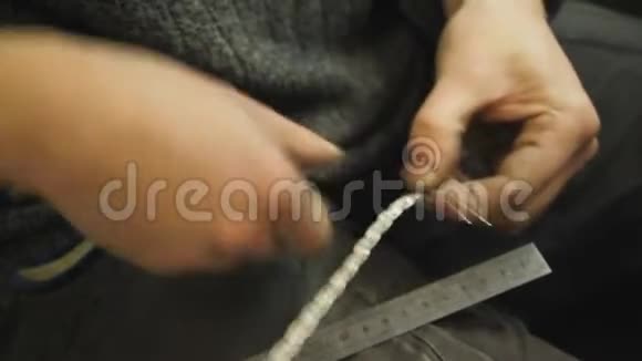 编织银手镯的特写一个珠宝大师的手做一个新产品选择性的聚焦视频的预览图