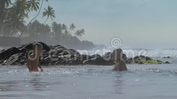 可爱的儿子和父亲一起在海水中玩耍视频的预览图