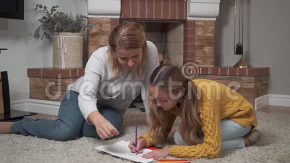 一位成年女子和女儿在家绘画的肖像可爱的白种人女孩在画的时候视频的预览图