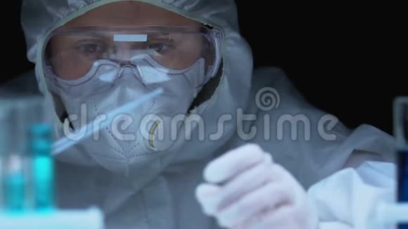 戴防护眼镜和呼吸器的女科学家取样液体实验室视频的预览图