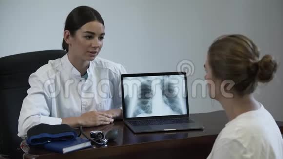 专业女医生告诉女性病人一些事情并在笔记本电脑屏幕上显示肺部x射线图像视频的预览图