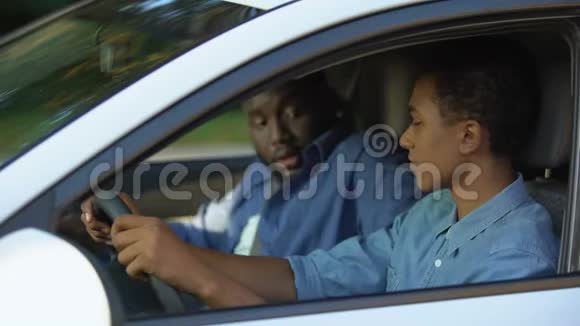 驾驶教练和男学生系安全带坐在车上有驾照视频的预览图