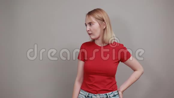 担心紧张的年轻女人看着一边咬着灰墙上孤立的嘴唇视频的预览图