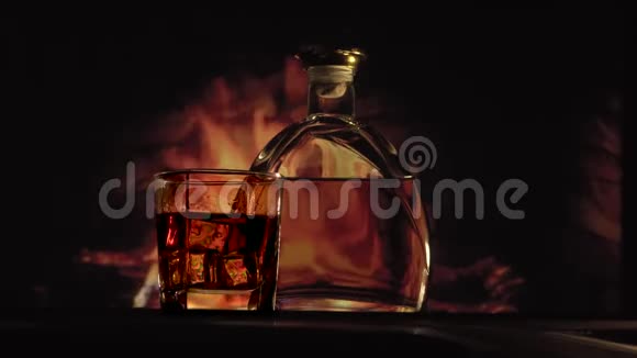 靠近壁炉的瓶子和酒杯视频的预览图
