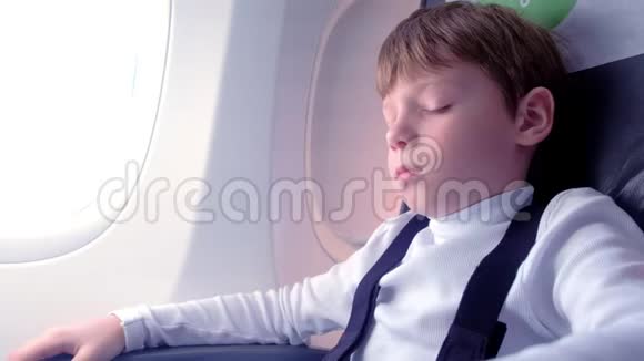 男孩睡在窗户旁边的飞机上侧视视频的预览图
