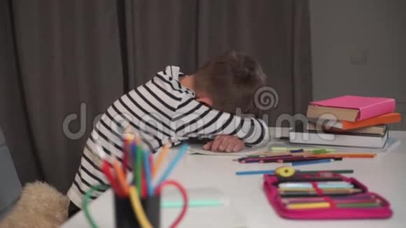 小白种人学童睡在他的练习本桌上孩子在家做作业后累了男孩在里面视频的预览图