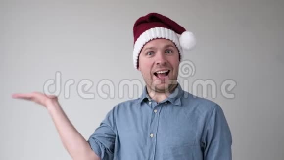 戴圣诞帽的男士在手掌上方显示空白复制空间供客户添加圣诞产品视频的预览图