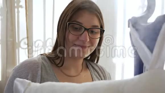 一个戴眼镜的年轻女人用蒸笼抚摸东西烫东西的过程视频的预览图