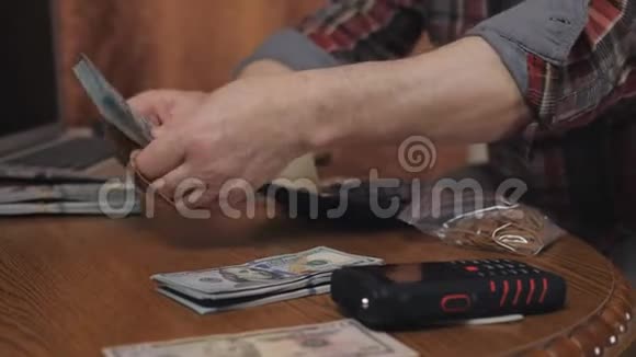 男退休清点现金储蓄一位数着美元钞票的老人的特写视频的预览图
